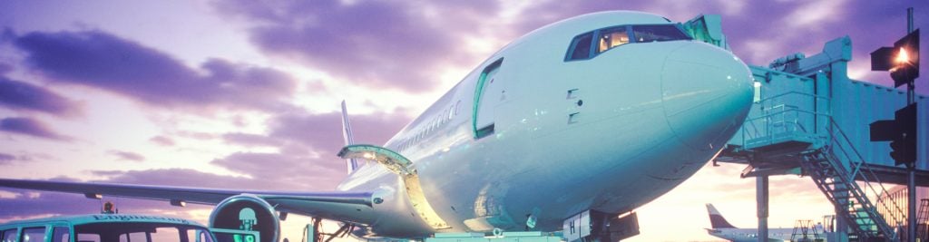 Boeing airplane on runway with sunset behind